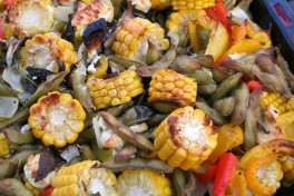 Charred corn on the cob, red peppers, cauliflower and edamame in a pan after roasting in the oven.
